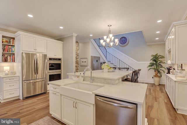 2165 Broadway, Hanover, PA 17331 - kitchen featuring stainless steel appliances, crown molding, white cabinetry, light wood-style floors, and a wainscoted wall