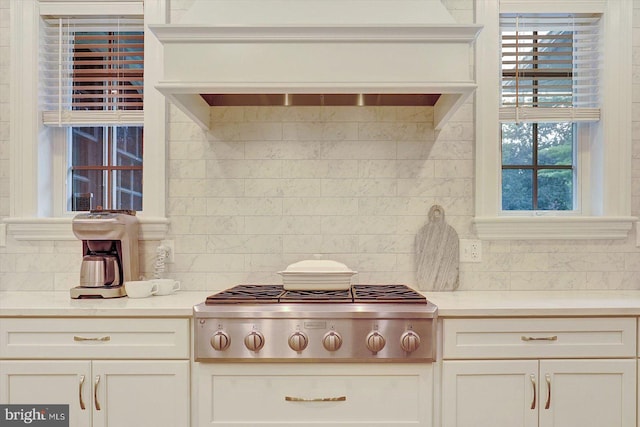 2165 Broadway, Hanover, PA 17331 - kitchen with stainless steel gas stovetop, backsplash, custom range hood, white cabinetry, and light countertops