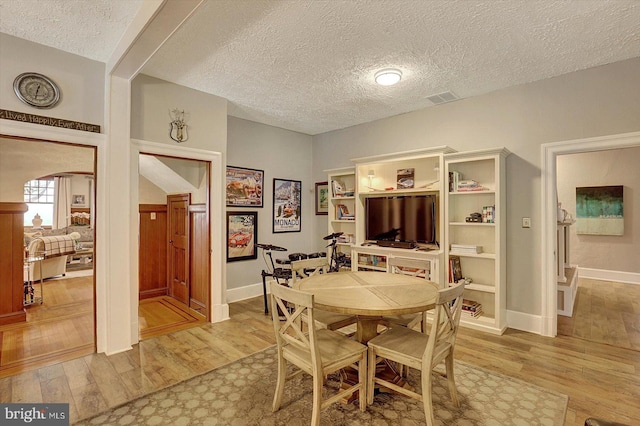 2165 Broadway, Hanover, PA 17331 - dining space featuring light wood-style flooring, a textured ceiling, and arched walkways