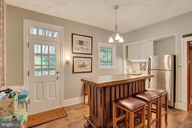 2165 Broadway, Hanover, PA 17331 - kitchen with freestanding refrigerator, a textured ceiling, light wood-style floors, a chandelier, and pendant lighting