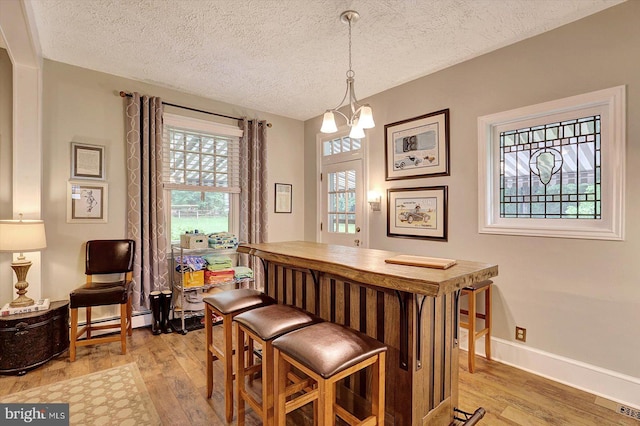 2165 Broadway, Hanover, PA 17331 - dining area with light wood-type flooring, a textured ceiling, a dry bar, baseboard heating, and a chandelier
