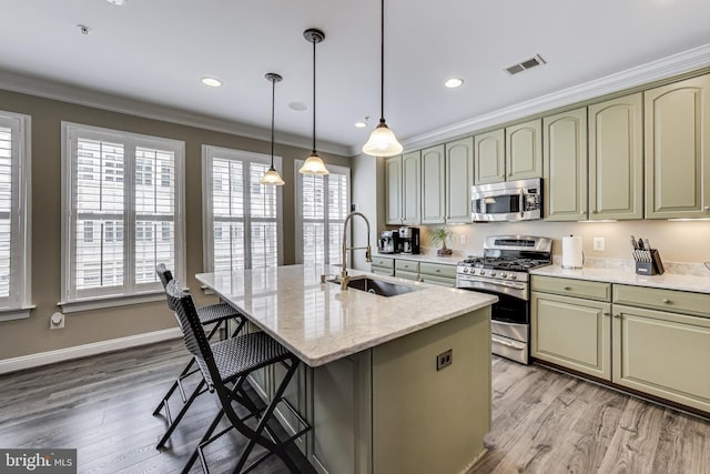 508 Rampart Way Unit 6, Oxon Hill, MD 20745 - kitchen with appliances with stainless steel finishes, light wood-style flooring, a kitchen breakfast bar, light stone counters, and an island with sink