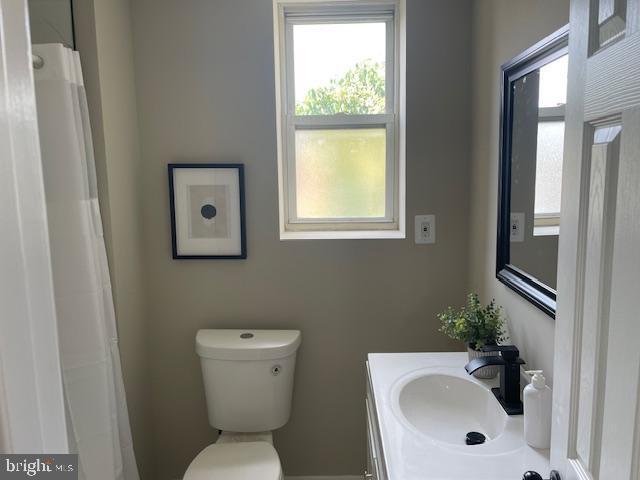 924 N Belnord Ave, Baltimore, MD 21205 - bathroom featuring toilet, vanity, and a shower with shower curtain