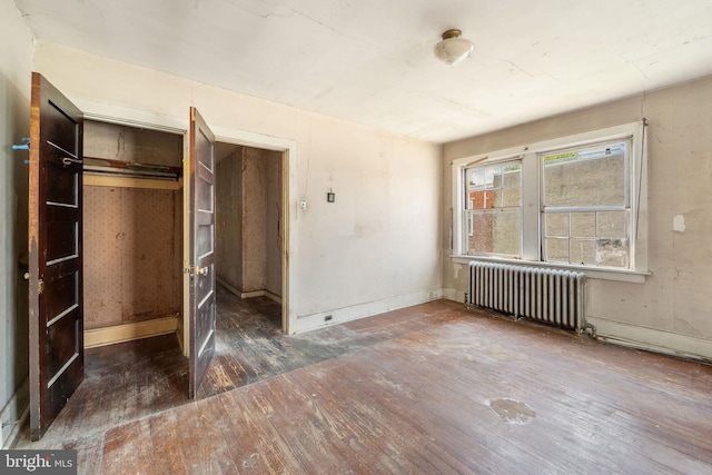 977 N 23rd St, Camden, NJ 08105 - unfurnished bedroom with radiator heating unit, wood-type flooring, and a closet