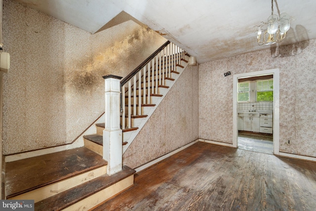 977 N 23rd St, Camden, NJ 08105 - stairs featuring hardwood / wood-style flooring, a chandelier, and wallpapered walls