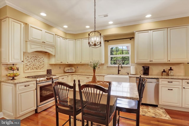 3930 Liz Cir, Doylestown, PA 18902 - kitchen featuring appliances with stainless steel finishes, light wood-style flooring, a chandelier, hanging light fixtures, and ornamental molding
