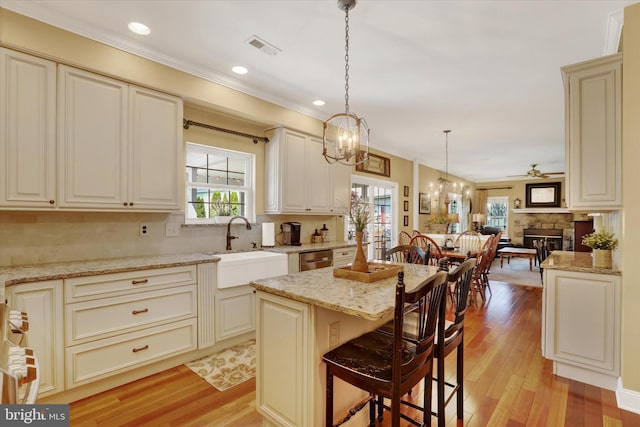 3930 Liz Cir, Doylestown, PA 18902 - kitchen featuring healthy amount of natural light, open floor plan, crown molding, light wood-style flooring, and light stone countertops