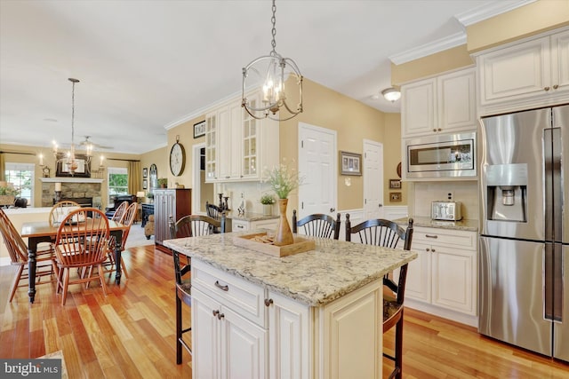 3930 Liz Cir, Doylestown, PA 18902 - kitchen with stainless steel appliances, a breakfast bar, a chandelier, light wood finished floors, and ornamental molding