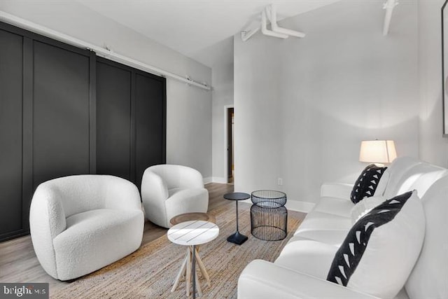1700 Kalorama Rd NW Unit 310, Washington, DC 20009 - living area featuring light wood-style floors, a barn door, and baseboards