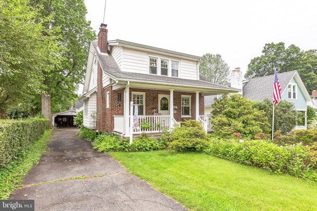 120 W Seventh St Unit 150, Media, PA 19063 - view of front of house featuring a chimney, a porch, brick siding, a front lawn, and asphalt driveway