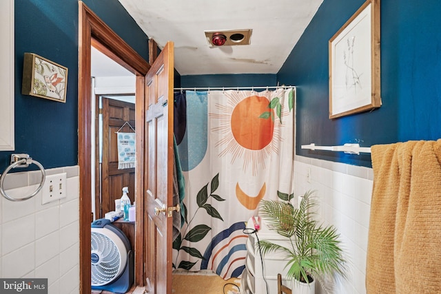 713 Washington St, Easton, PA 18042 - full bath featuring tile walls, wainscoting, and a shower with shower curtain