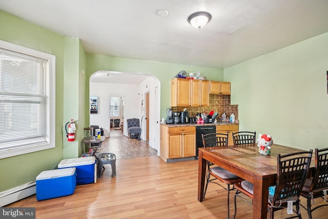 713 Washington St, Easton, PA 18042 - dining area featuring arched walkways, a baseboard heating unit, and light wood finished floors