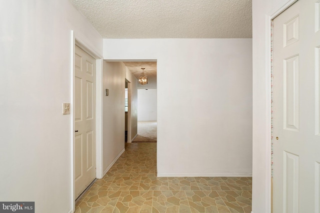 30 Hilltop Ln W, Columbus, NJ 08022 - corridor featuring a textured ceiling, light stone finish floors, and a chandelier