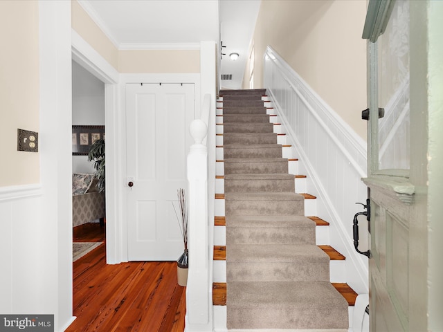 414 S Aurora St, Easton, MD 21601 - stairs featuring wood finished floors, a wainscoted wall, crown molding, and a decorative wall