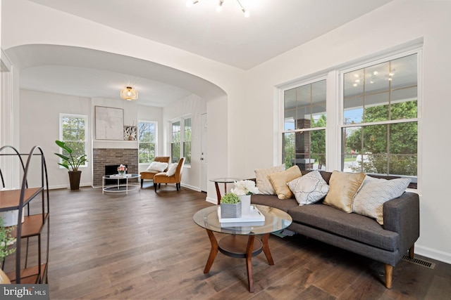 201 Parkway St, Winchester, VA 22601 - living area with arched walkways, dark wood-style floors, baseboards, and a brick fireplace