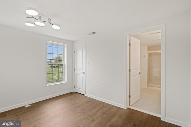 201 Parkway St, Winchester, VA 22601 - unfurnished bedroom with wood finished floors, baseboards, and connected bathroom