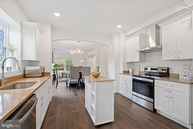 201 Parkway St, Winchester, VA 22601 - kitchen featuring stainless steel appliances, wall chimney range hood, arched walkways, a sink, and white cabinetry