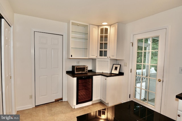 4 W Woodduck Dr, Tuckerton, NJ 08087 - kitchen featuring wine cooler, dark countertops, white cabinetry, glass insert cabinets, and baseboards
