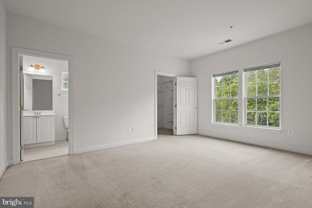 14014 Mary Bowie Pkwy, Upper Marlboro, MD 20774 - unfurnished bedroom with light colored carpet, a walk in closet, multiple windows, and ensuite bathroom