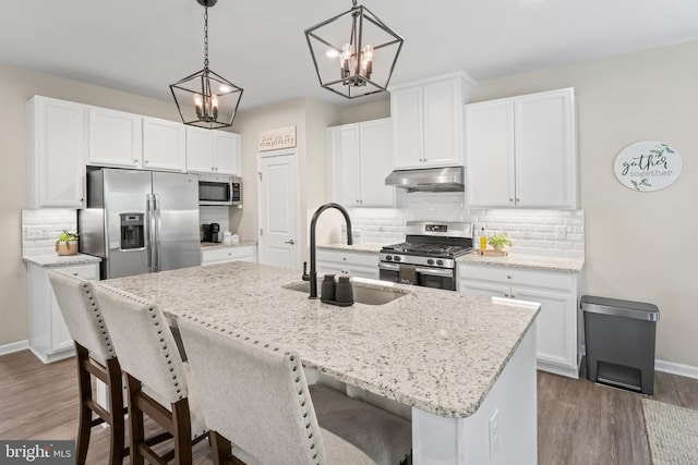 57 Oak Ln, Carneys Point, NJ 08069 - kitchen featuring appliances with stainless steel finishes, under cabinet range hood, dark wood-type flooring, and a chandelier
