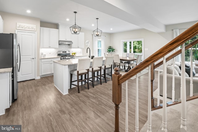 57 Oak Ln, Carneys Point, NJ 08069 - kitchen with appliances with stainless steel finishes, under cabinet range hood, wood finished floors, recessed lighting, and white cabinets