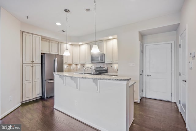 7493 Brunson Cir, Gainesville, VA 20155 - kitchen featuring appliances with stainless steel finishes, dark wood finished floors, light stone counters, a kitchen island with sink, and recessed lighting