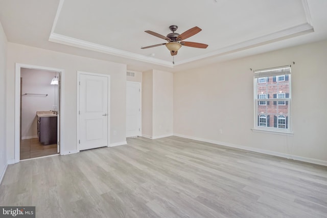 7493 Brunson Cir, Gainesville, VA 20155 - unfurnished bedroom with a raised ceiling, light wood-style flooring, and ensuite bath