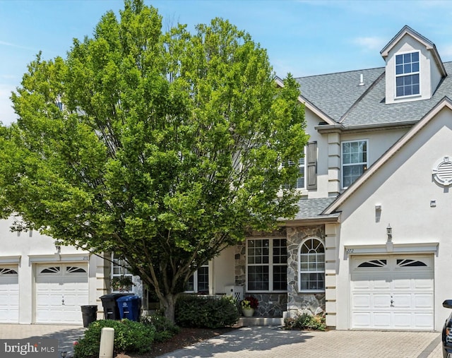 272 Center Point Ln, Lansdale, PA 19446 - view of front facade with a shingled roof, stucco siding, decorative driveway, a garage, and stone siding