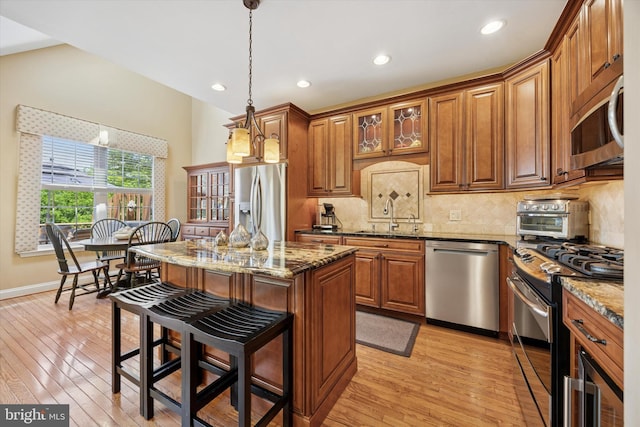 272 Center Point Ln, Lansdale, PA 19446 - kitchen featuring appliances with stainless steel finishes, brown cabinetry, light wood-style flooring, a breakfast bar area, and recessed lighting
