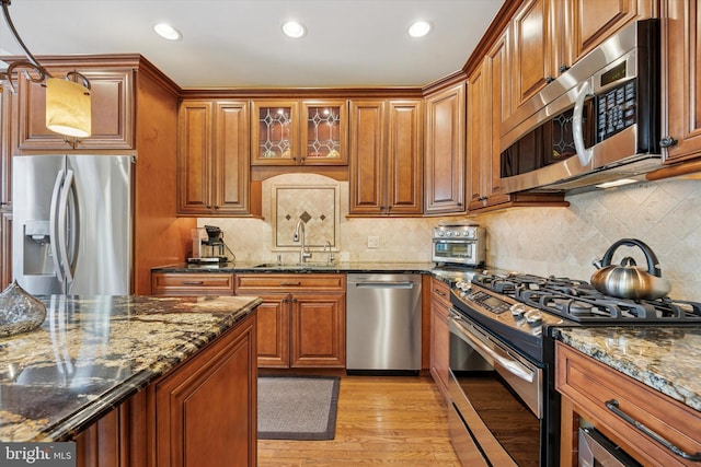 272 Center Point Ln, Lansdale, PA 19446 - kitchen featuring appliances with stainless steel finishes, brown cabinets, dark stone countertops, recessed lighting, and light wood finished floors