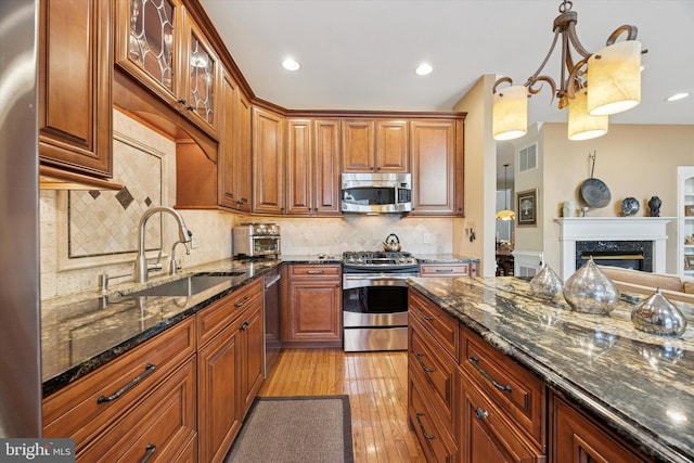 272 Center Point Ln, Lansdale, PA 19446 - kitchen featuring stainless steel appliances, light wood-type flooring, dark stone countertops, glass insert cabinets, and tasteful backsplash