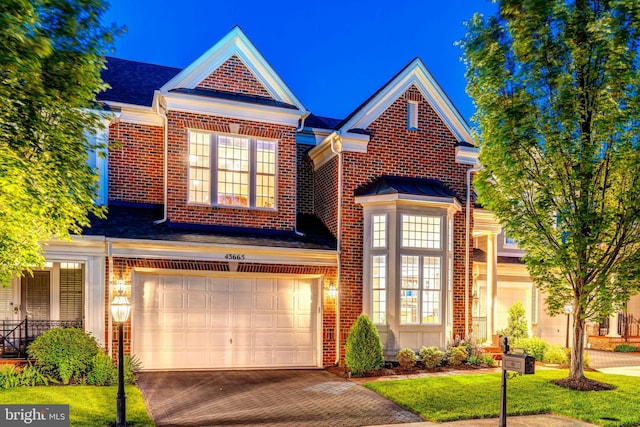 43665 Jernigan Ter, Leesburg, VA 20176 - view of front facade with an attached garage, brick siding, decorative driveway, and a front yard