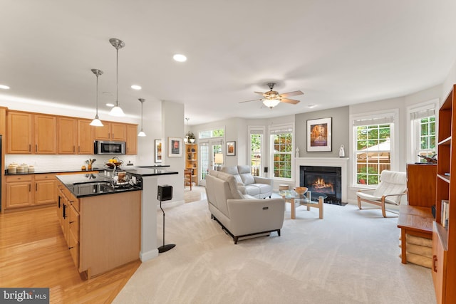 43665 Jernigan Ter, Leesburg, VA 20176 - living area with healthy amount of natural light, a glass covered fireplace, a ceiling fan, and recessed lighting