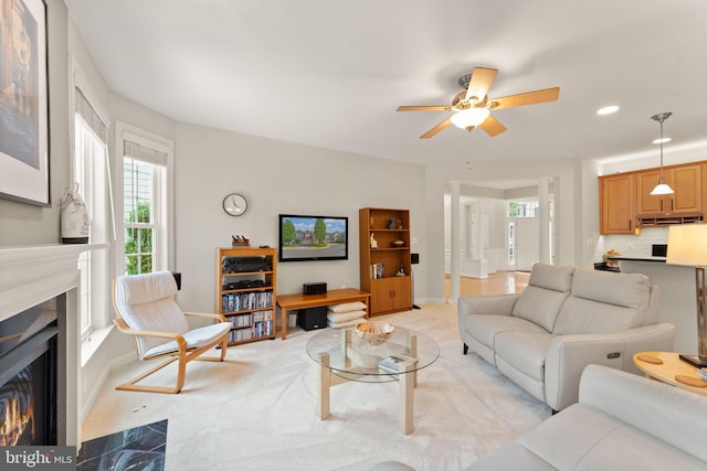 43665 Jernigan Ter, Leesburg, VA 20176 - living room with a glass covered fireplace, a ceiling fan, healthy amount of natural light, ornate columns, and recessed lighting