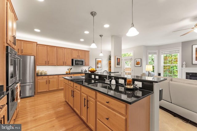 43665 Jernigan Ter, Leesburg, VA 20176 - kitchen featuring open floor plan, appliances with stainless steel finishes, a center island with sink, a ceiling fan, and light wood-type flooring