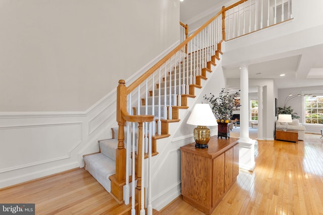 43665 Jernigan Ter, Leesburg, VA 20176 - stairs with ornate columns, hardwood / wood-style floors, recessed lighting, a towering ceiling, and a decorative wall