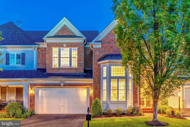 43665 Jernigan Ter, Leesburg, VA 20176 - view of front of house with driveway, roof with shingles, a garage, brick siding, and a front lawn