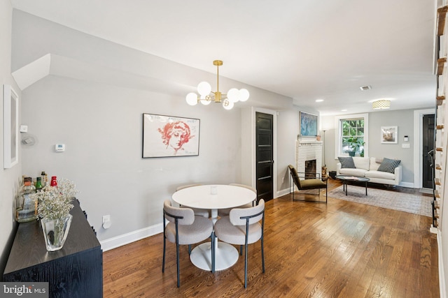 407 Independence Ave SE, Washington, DC 20003 - dining area with hardwood / wood-style floors, a brick fireplace, and a chandelier