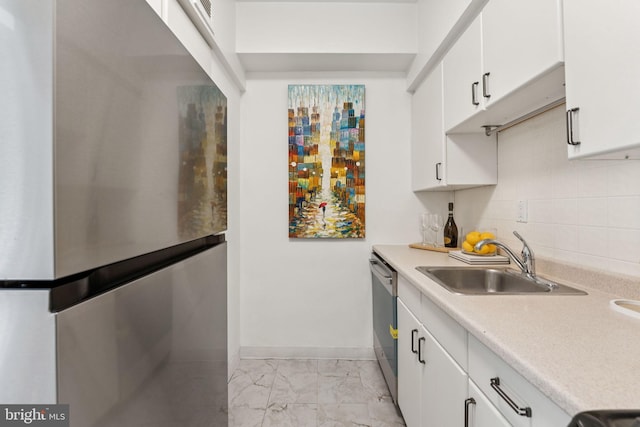 1711 Massachusetts Ave NW Unit 230, Washington, DC 20036 - kitchen featuring appliances with stainless steel finishes, light marble finish floors, light countertops, white cabinetry, and backsplash