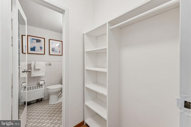 1711 Massachusetts Ave NW Unit 230, Washington, DC 20036 - bathroom with radiator, tile walls, and a wainscoted wall