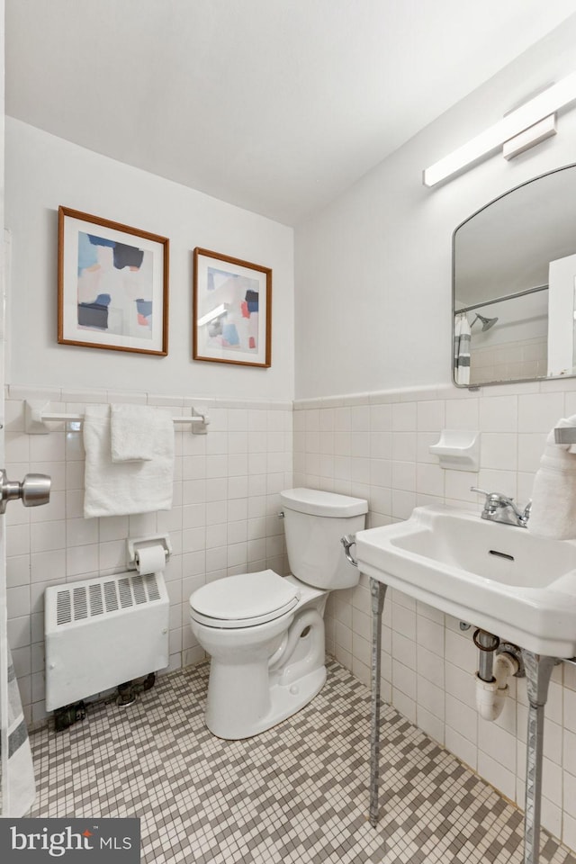 1711 Massachusetts Ave NW Unit 230, Washington, DC 20036 - bathroom with radiator heating unit, tile walls, and wainscoting