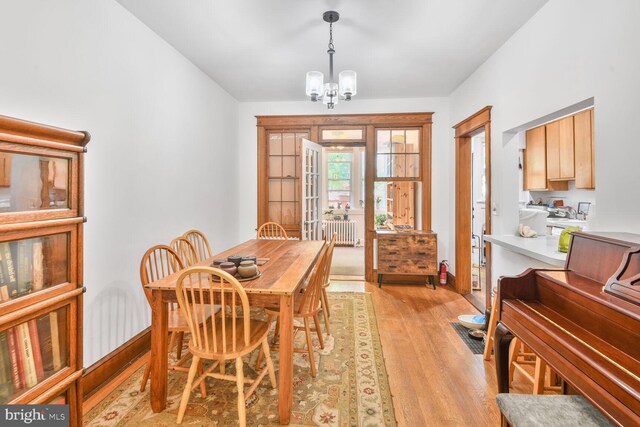 3905 Benton St NW, Washington, DC 20007 - dining area featuring light wood finished floors, radiator, and a chandelier