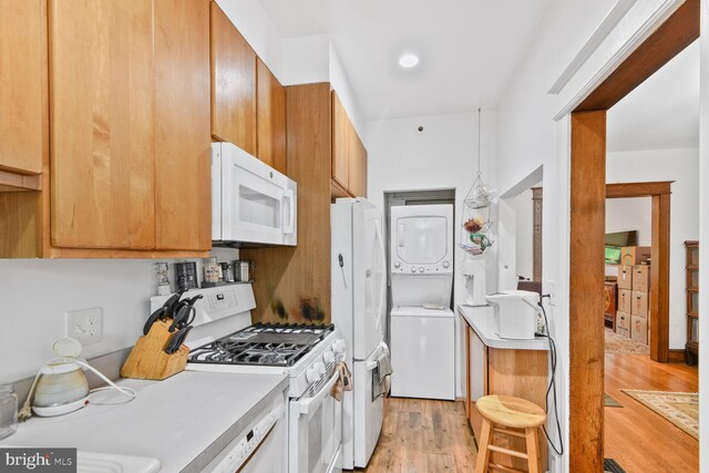 3905 Benton St NW, Washington, DC 20007 - kitchen with white appliances, stacked washer / drying machine, light wood-style floors, and light countertops