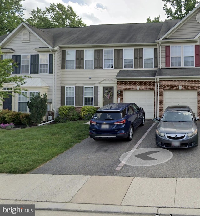 7220 Bocastle Ln, Hanover, MD 21076 - townhome / multi-family property with driveway, an attached garage, brick siding, and a front lawn
