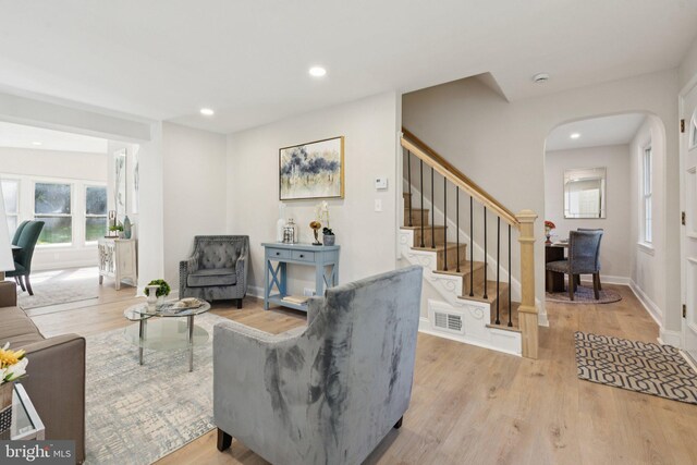9215 Glenville Rd, Silver Spring, MD 20901 - living room featuring wood finished floors, stairs, arched walkways, and recessed lighting