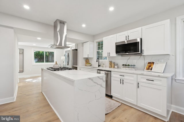 9215 Glenville Rd, Silver Spring, MD 20901 - kitchen with appliances with stainless steel finishes, island exhaust hood, a center island, white cabinetry, and light wood-style flooring