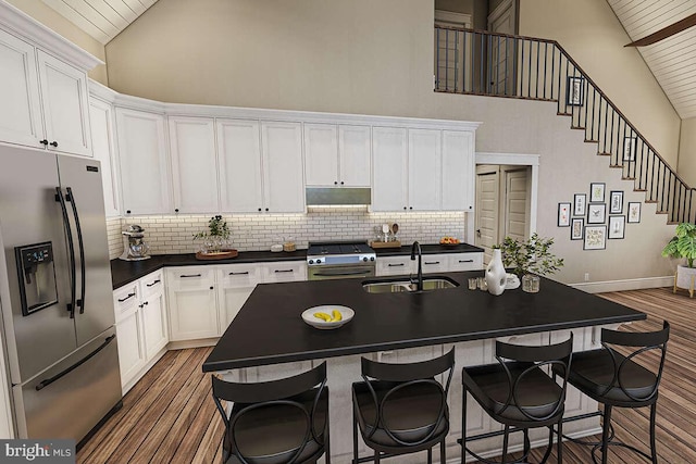 2802 High Top Rd, Linden, VA 22642 - kitchen with stainless steel fridge, high vaulted ceiling, gas stove, dark countertops, and under cabinet range hood
