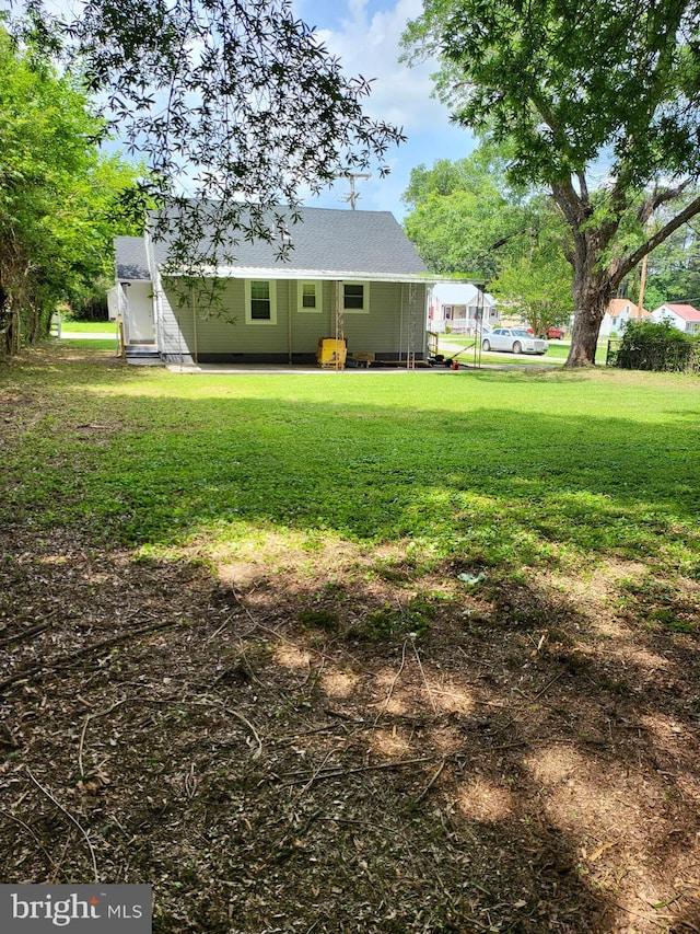 501 Tunstall Ave, Blackstone, VA 23824 - back of property featuring a yard, a shingled roof, and a patio