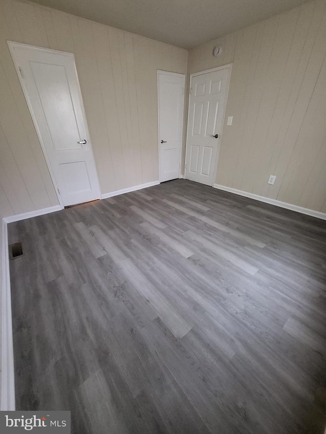 501 Tunstall Ave, Blackstone, VA 23824 - empty room featuring dark wood-style floors and wood walls