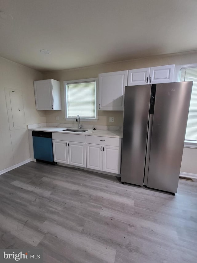 501 Tunstall Ave, Blackstone, VA 23824 - kitchen with dishwashing machine, freestanding refrigerator, white cabinets, light wood finished floors, and light countertops